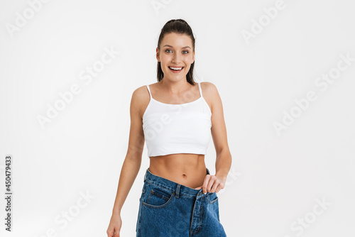 European brunette woman smiling while posing in big jeans