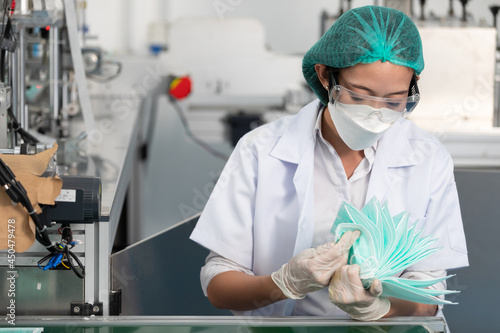 woman factory worker are producing medical face masks  counting and checking of quality from machine