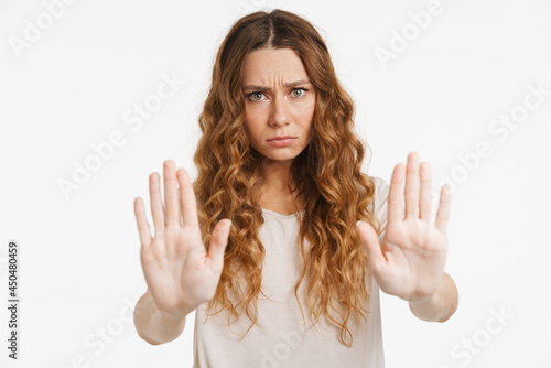 Young ginger woman frowning while showing stop gesture