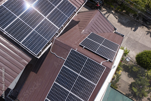 A Polycrystalline Solar panel system mounted on a ribbed metal roofing of a house. photo