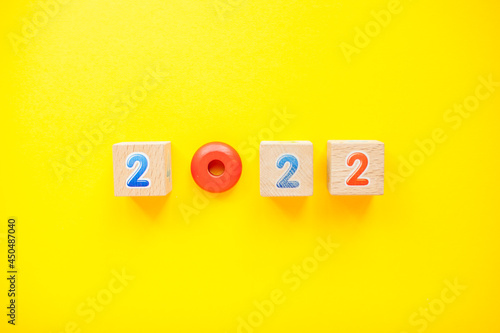 Numbers 2022 from childrens cubes and toys on a bright yellow background. New Year. High quality photo