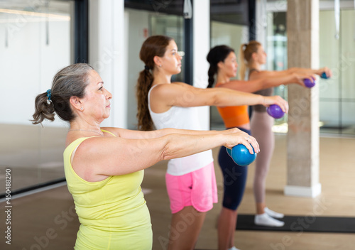 Women of different ages doing exercises with spherical dumbbells