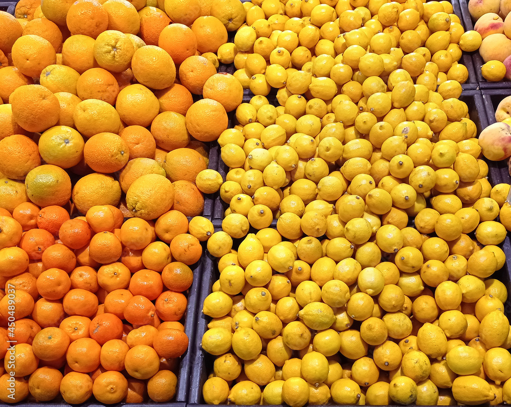Many juicy bright yellow lemons on a market counter. Close-up. Background.