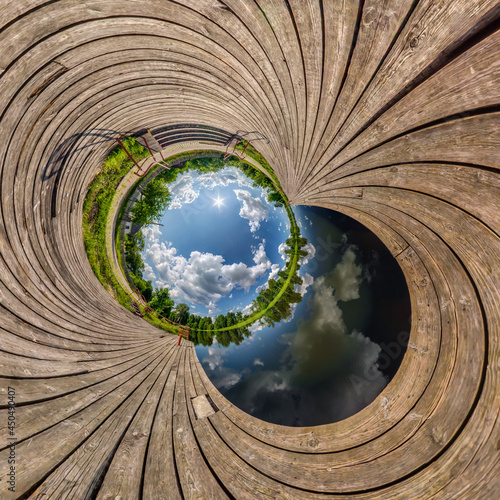 blue sphere little planet inside transformation of wooden pier and lake.