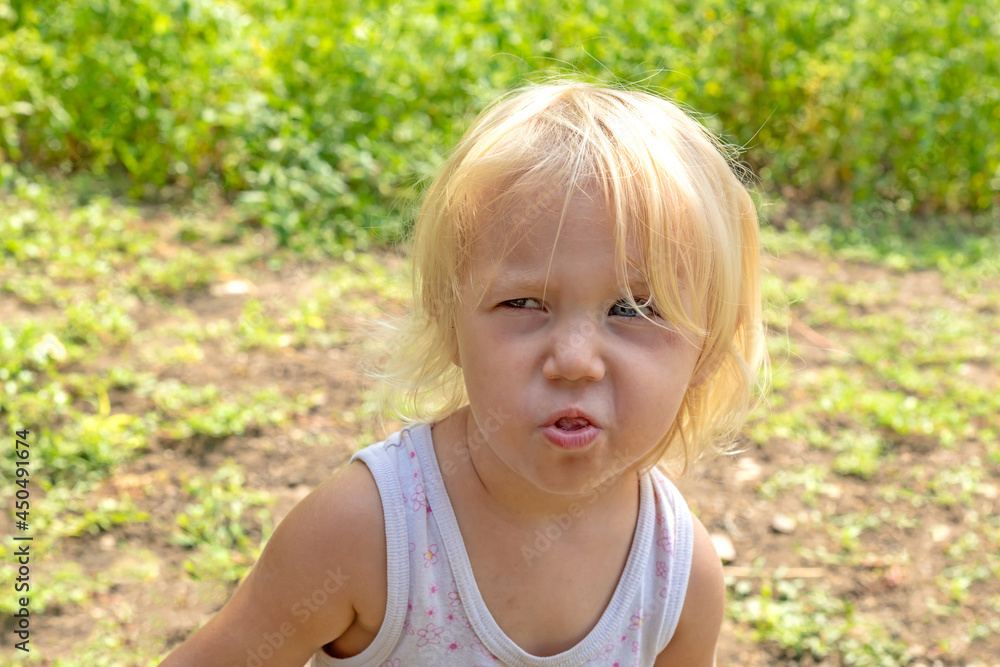 The child saw the camera and grimaces his face as best he can. The child saw the camera and grimaces his face as best he can.