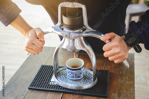 hands showing making espresso coffee ahot from machine in drinking style