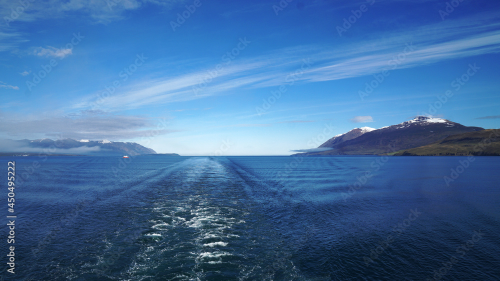 the ship leaves against the backdrop of snowy mountains and the horizon at sea, Akureyri, Iceland the ship leaves against the backdrop of snowy mountains and the horizon at sea, Akureyri, Iceland