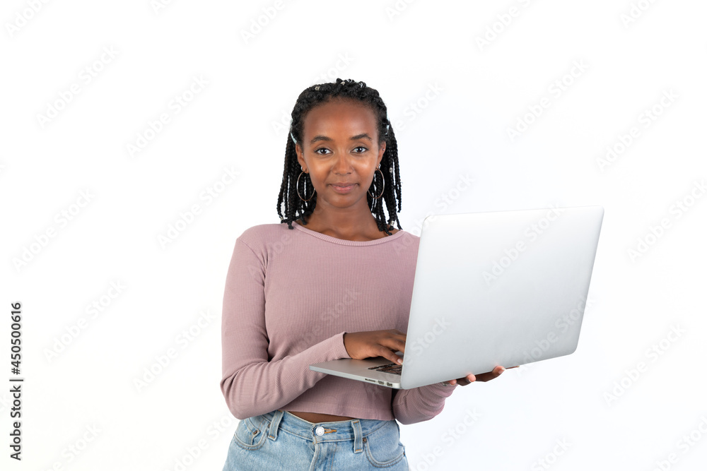 Student woman holding a laptop and writing on it, looking at camera. White background. African-Ethiopian black woman. Student woman holding a laptop and writing on it, looking at camera. White background. African-Ethiopian black woman.