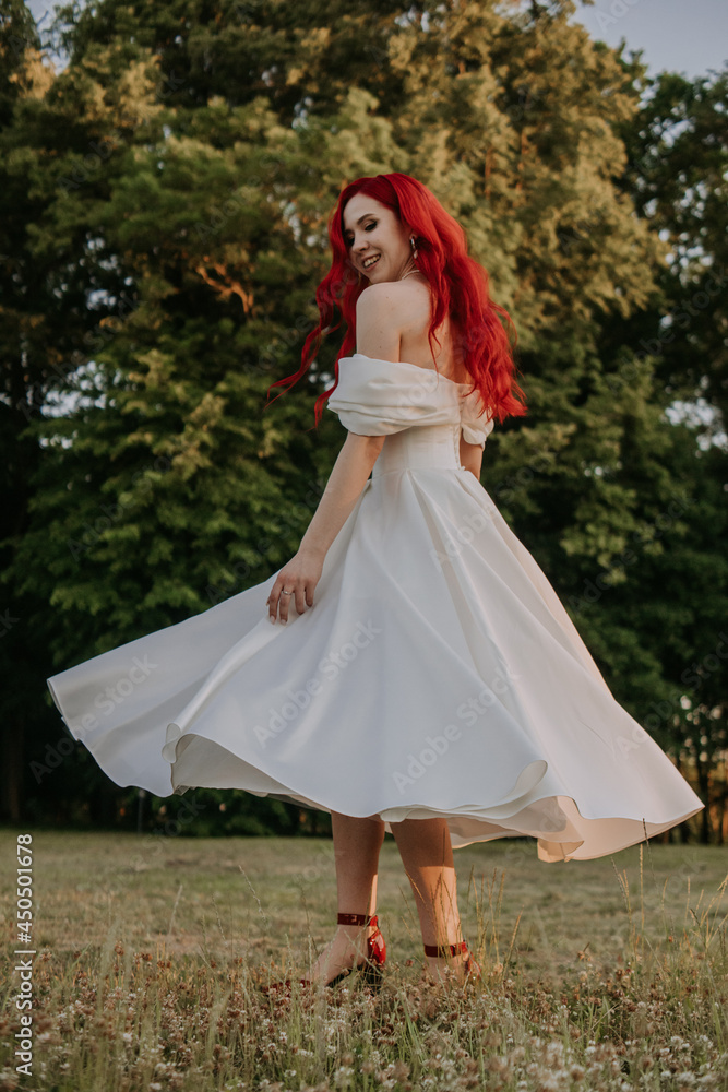 Wedding day. Happy bride with redhead whirling and laughing in the park Wedding day. Happy bride with redhead whirling and laughing in the park