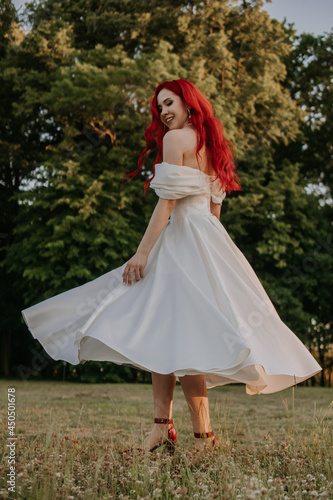 Wedding day. Happy bride with redhead whirling and laughing in the park