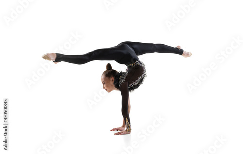 Young girl, rhythmic gymnastics artist training isolated on white studio background. Concept of sport, action, aspiration, education, active lifestyle