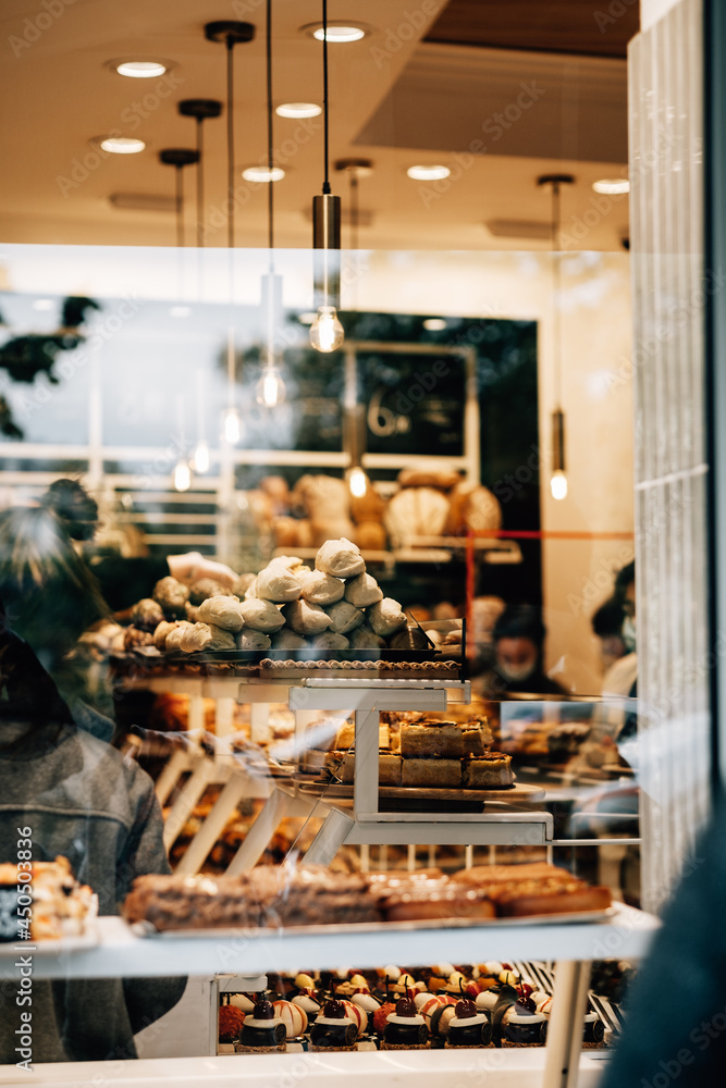 Φωτογραφία Vertical shot from outside of a full of customers bakery shop with tasty dessert