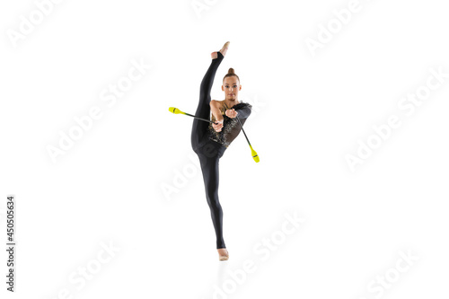 One Caucasian girl, rhythmic gymnastics artist practicing with baton isolated on white studio background. Concept of sport, action, aspiration, education, active lifestyle photo