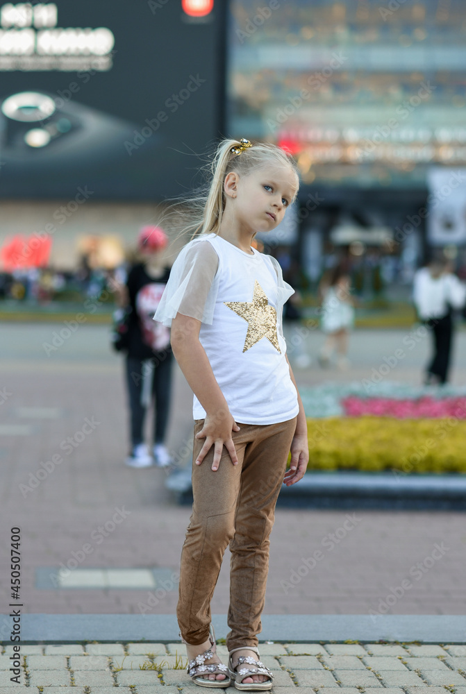 Little girl model walking in the city square