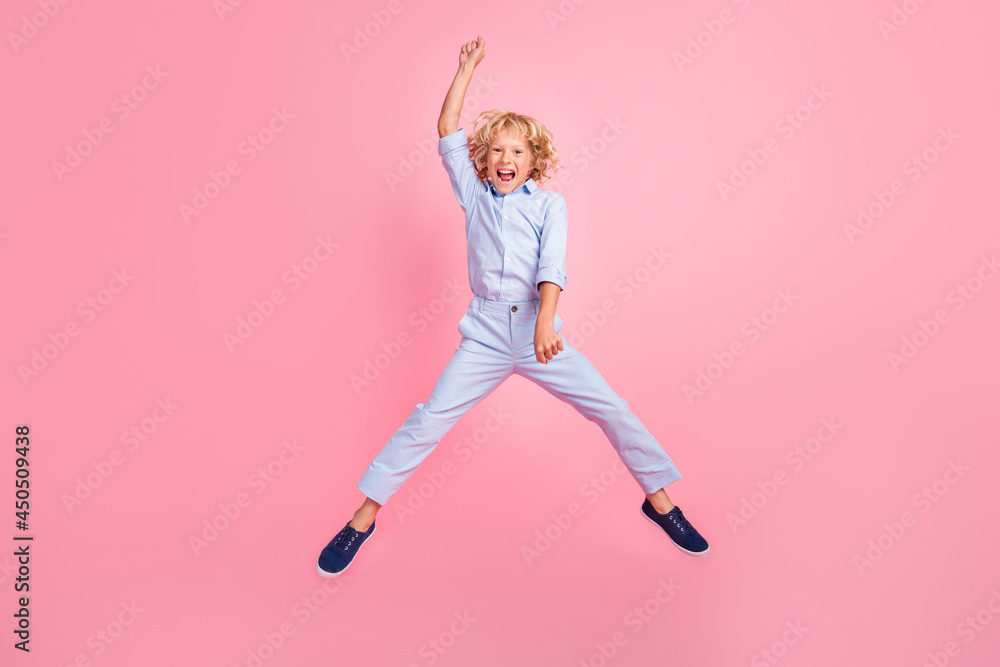 Full size photo of funky funny carefree smiling schoolboy jumping fooling around isolated on pink color background