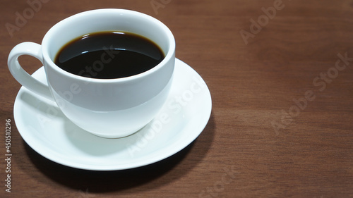 Black coffee in a white cup on wooden table, Close up
