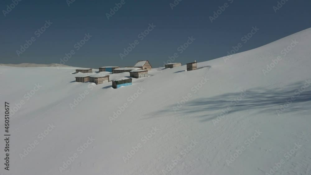 Aerial view of an alpine settlement on a background of snow-covered winter mountains. Ukraine Carpathians. Aerial view of an alpine settlement on a background of snow-covered winter mountains. Ukraine Carpathians.