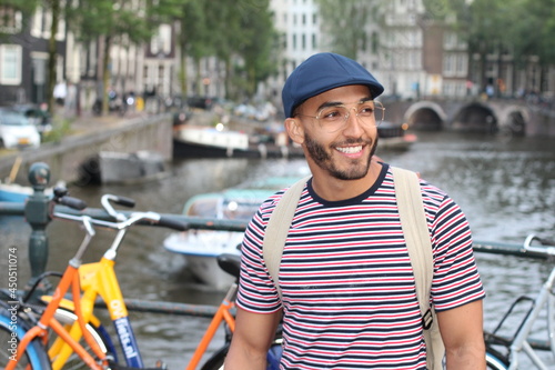 Young mixed race man enjoying a European cityscape view with a river