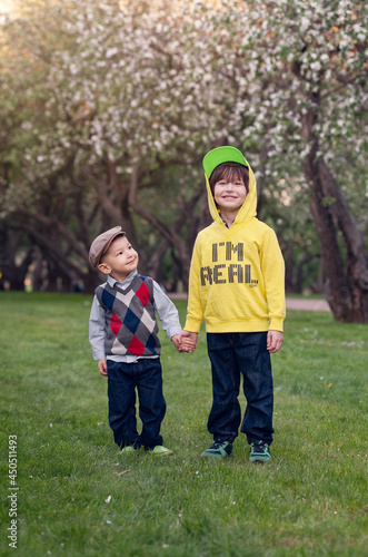 Portrait of a two cute stylishly dressed brothers .Outdoor, close up. summer time photo .