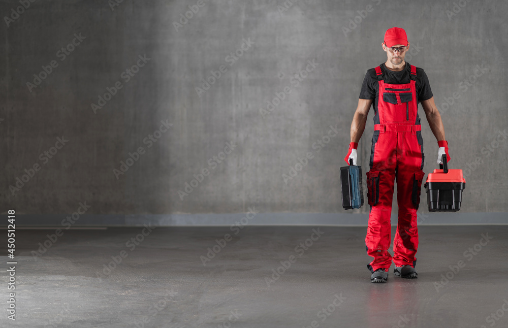 Construction Worker in Red Uniform Walking with Toolboxes in His Hands