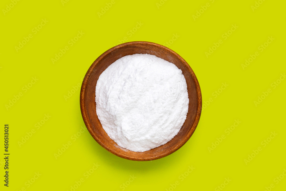 Baking soda in wooden bowl on green background. Baking soda in wooden bowl on green background.