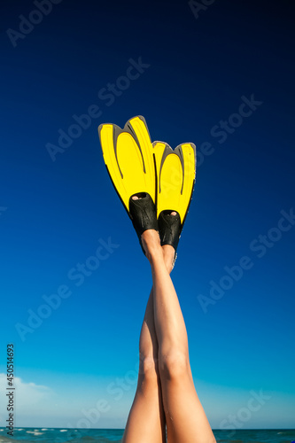 female legs shod in flippers raised up in summer
