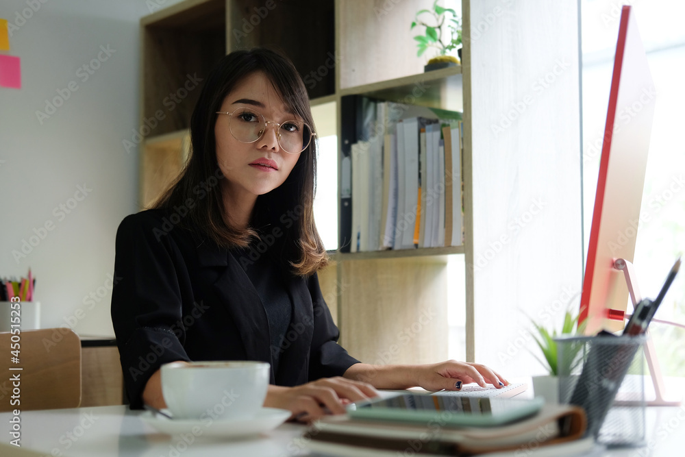Businesswoman sitting in office and looking at camera. Businesswoman sitting in office and looking at camera.