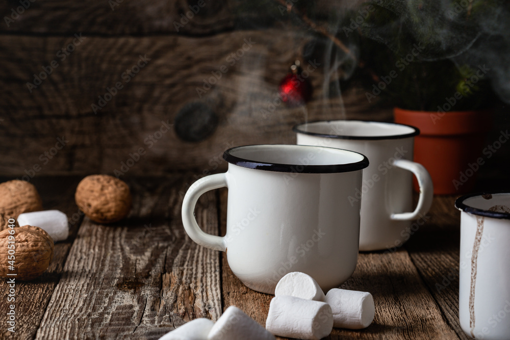 Hot cocoa in white mugs with sweet marshmallows on rustic wooden table Hot cocoa in white mugs with sweet marshmallows on rustic wooden table