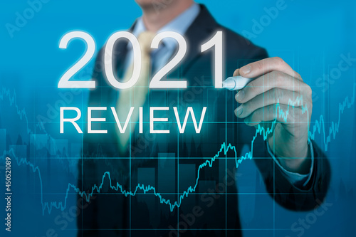 businessman writes 2021 review words. businessman writes 2021 results on virtual screen. economic indicators, overcoming the crisis and economic recovery after the coronavirus pandemic in 2021