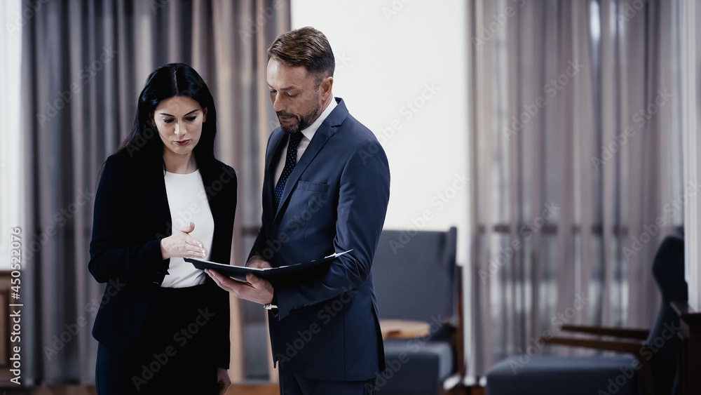 Business people looking at papers in lobby of restaurant