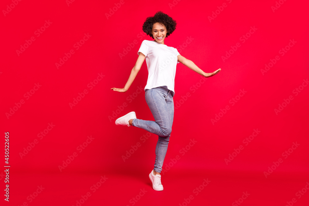 Full length body size photo smiling curly woman wearing stylish outfit isolated bright red color background