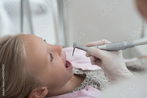 A little blonde child having teeth treatment at the dentists photo