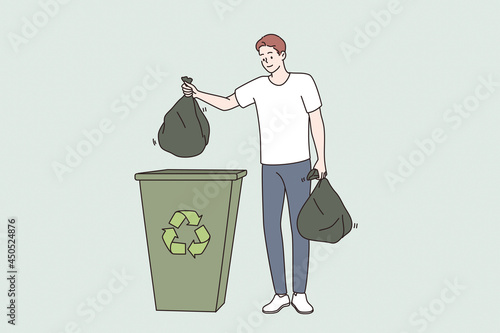 Saving ecology and recycling concept. Young smiling man cartoon character standing holding trash bags separated for recycling vector illustration 