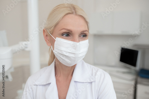 A blonde female doctor wearing a protective mask photo