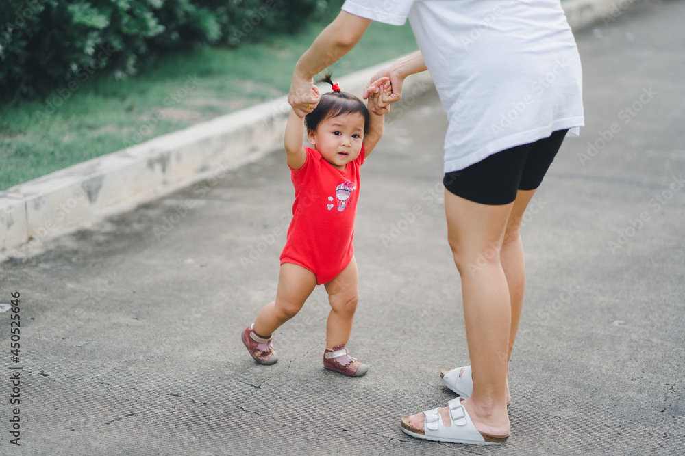 baby step in outdoor to practice balance walk in development according to the age of the child with mother helping daughter support baby step in outdoor to practice balance walk in development according to the age of the child with mother helping daughter support