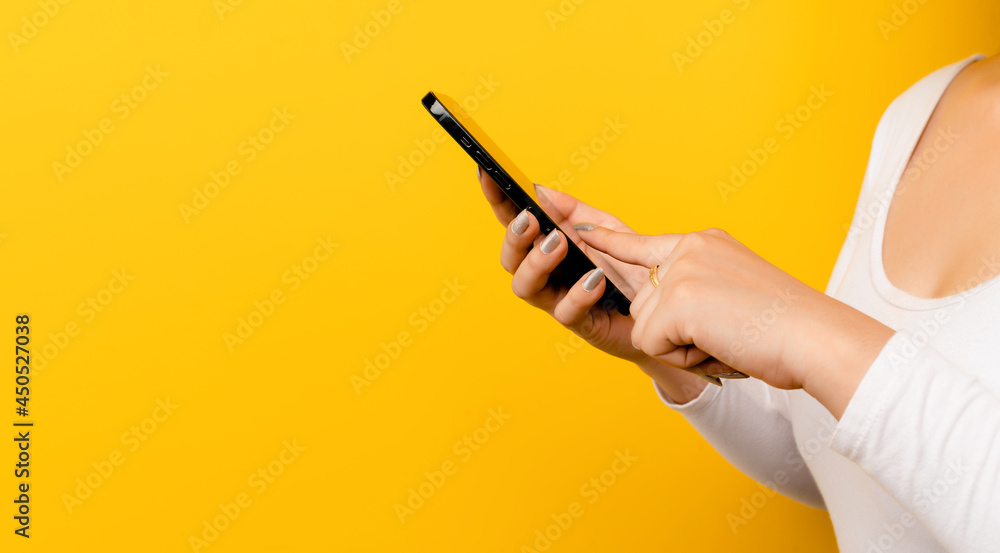 close-up online communication Asian woman using a smartphone on a yellow background with free space close-up online communication Asian woman using a smartphone on a yellow background with free space