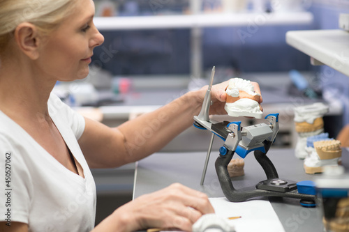 A female prosthetist working with plaster prosthesis photo