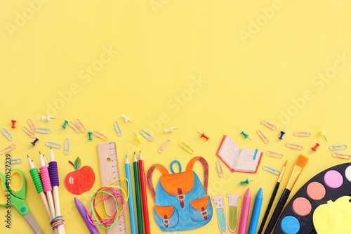 Back to school concept. Top view image of student stationery over pastel yellow background