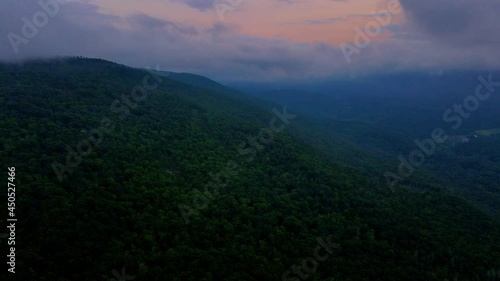 Foggy, cloudy, aerial drone video footage of nightfall in the Appalachian Mountains, during summer, with the afterglow of sunset still in the background. photo