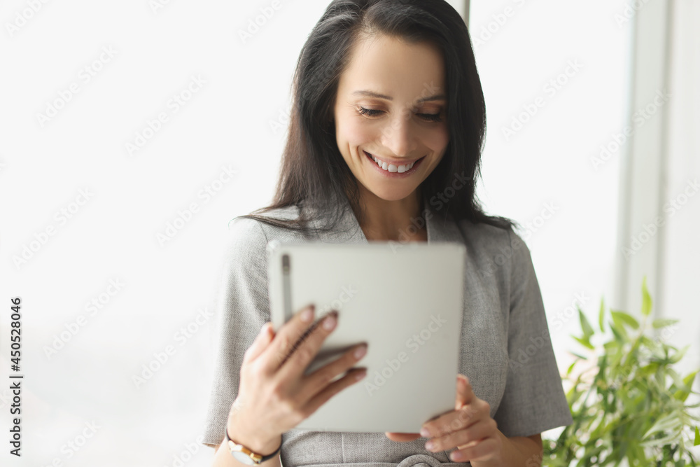 Smiling young woman in suit holding digital tablet Smiling young woman in suit holding digital tablet