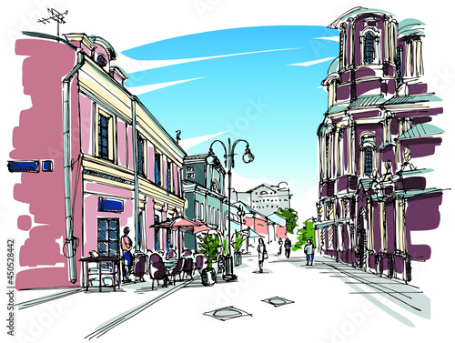 Quiet pedestrian city center street with churches and coffee house tables