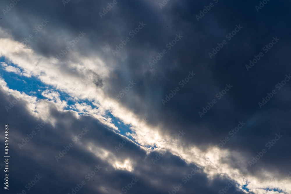 Fototapeta premium Rays of light shining throug dark clouds.Beautiful dramatic sky with sun rays.