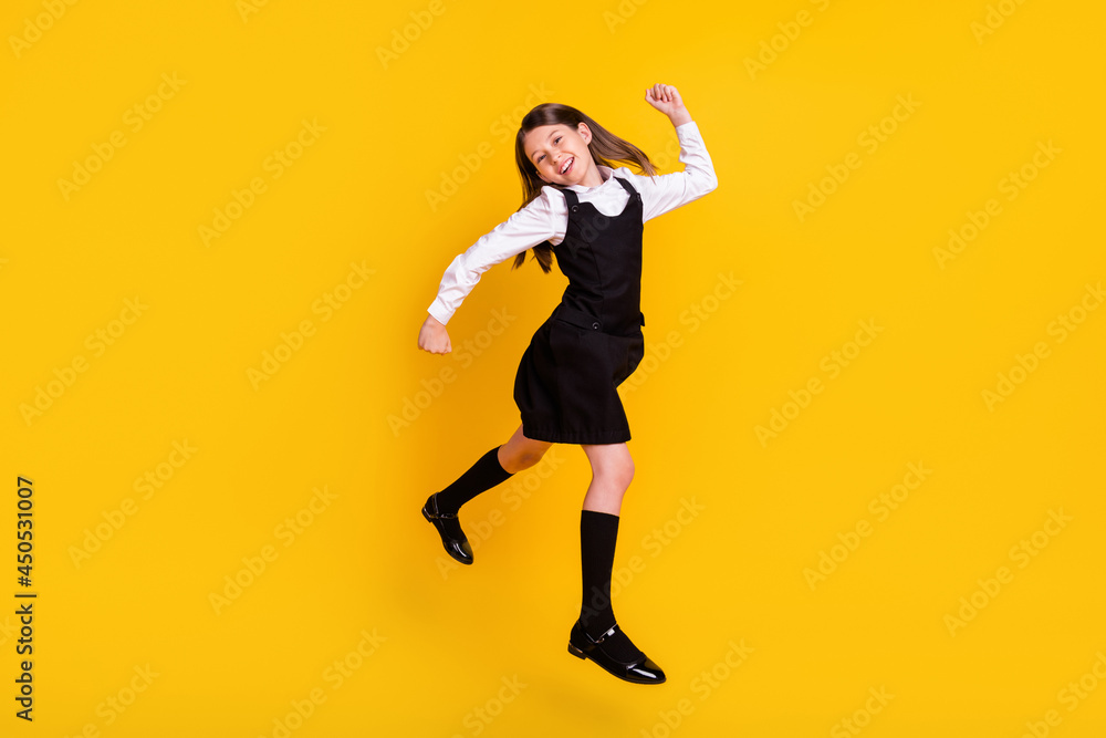 Full length body size photo schoolgirl in uniform jumping gesturing like winner isolated bright yellow color background