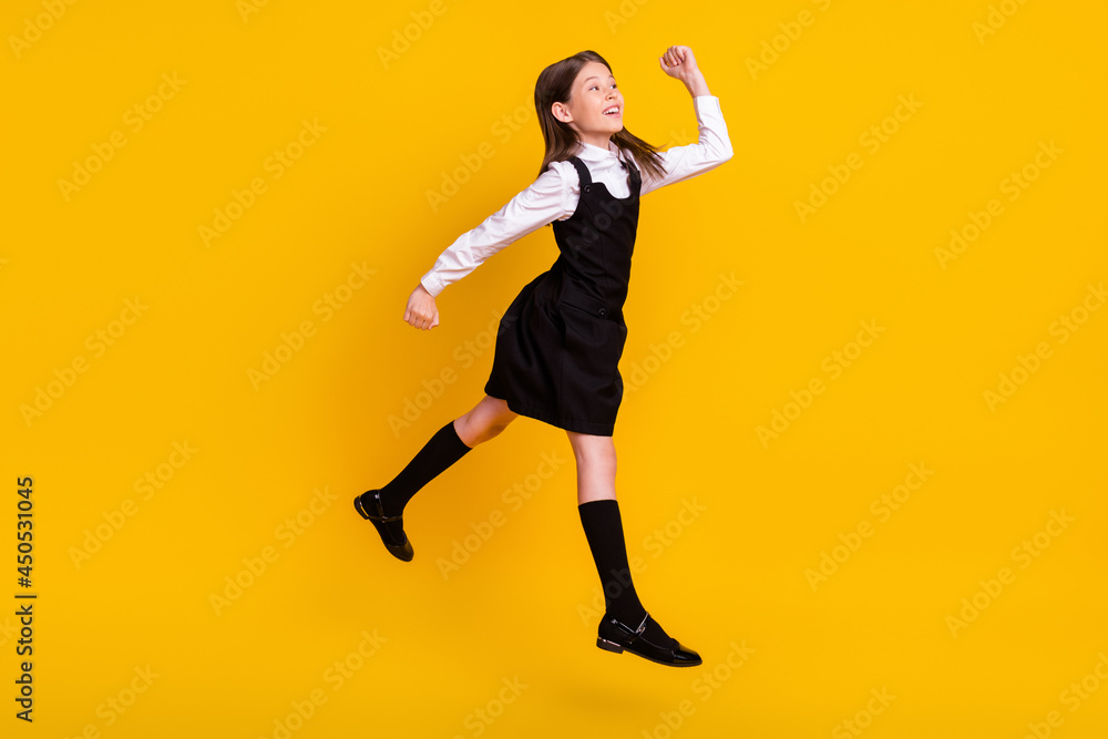 Full length body size side photo schoolgirl in uniform jumping gesturing like winner isolated vivid yellow color background