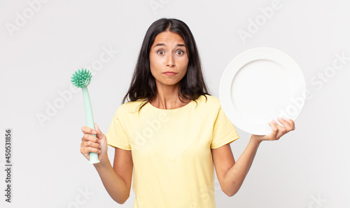 pretty hispanic woman holding an epty clean dish photo