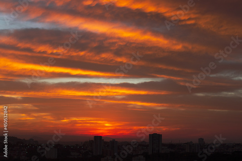 Sunrise skyline with red color fire on a cloudy winter day on a city. Space for text.