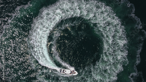 An aerial view of a boat sailing in a circle essentially making a donut in the ocean.  © Dmitry