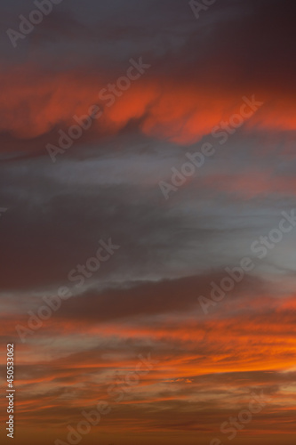 Sunrise sky with red color fire on a cloudy winter day. Space for text.