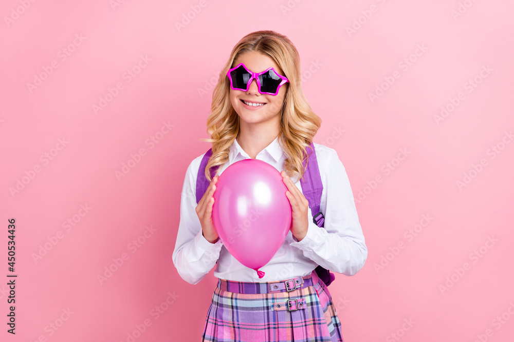 Portrait of pretty cheerful girl wearing star specs holding helium ball isolated over pink pastel color background Portrait of pretty cheerful girl wearing star specs holding helium ball isolated over pink pastel color background