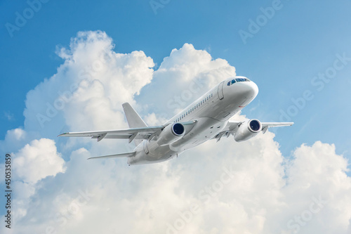 Take off of a white passenger commercial liner against the backdrop of a fluffy cumulus cloud illuminated by the sun.